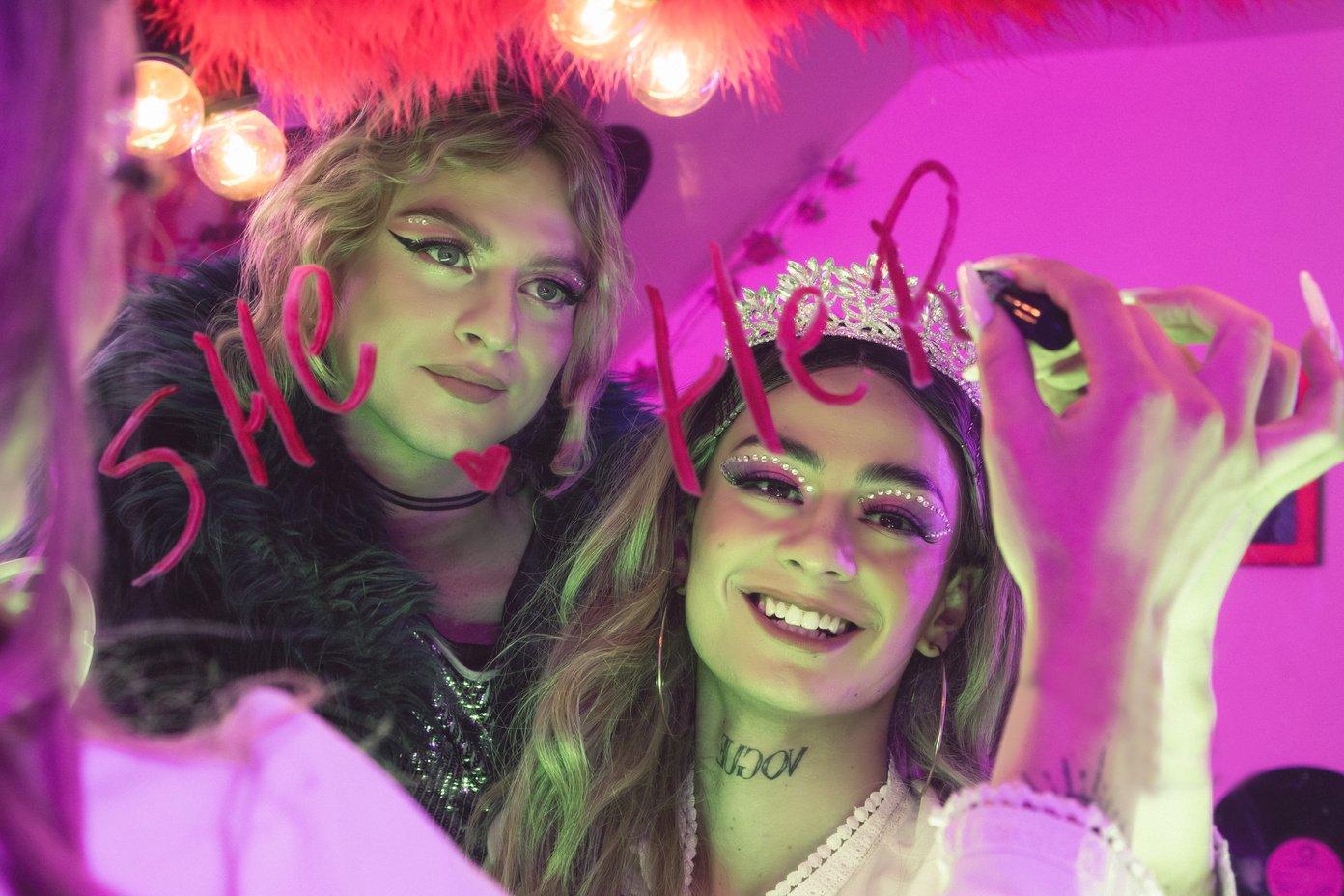 Two Friends Writing the Word Her on Mirror with Lipstick