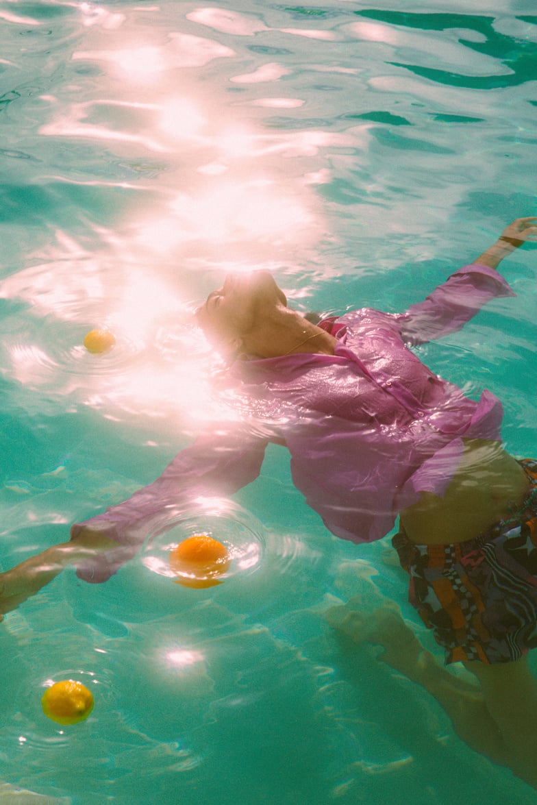 Man in Summer Dress Shirt Relaxing in Pool with Lemons